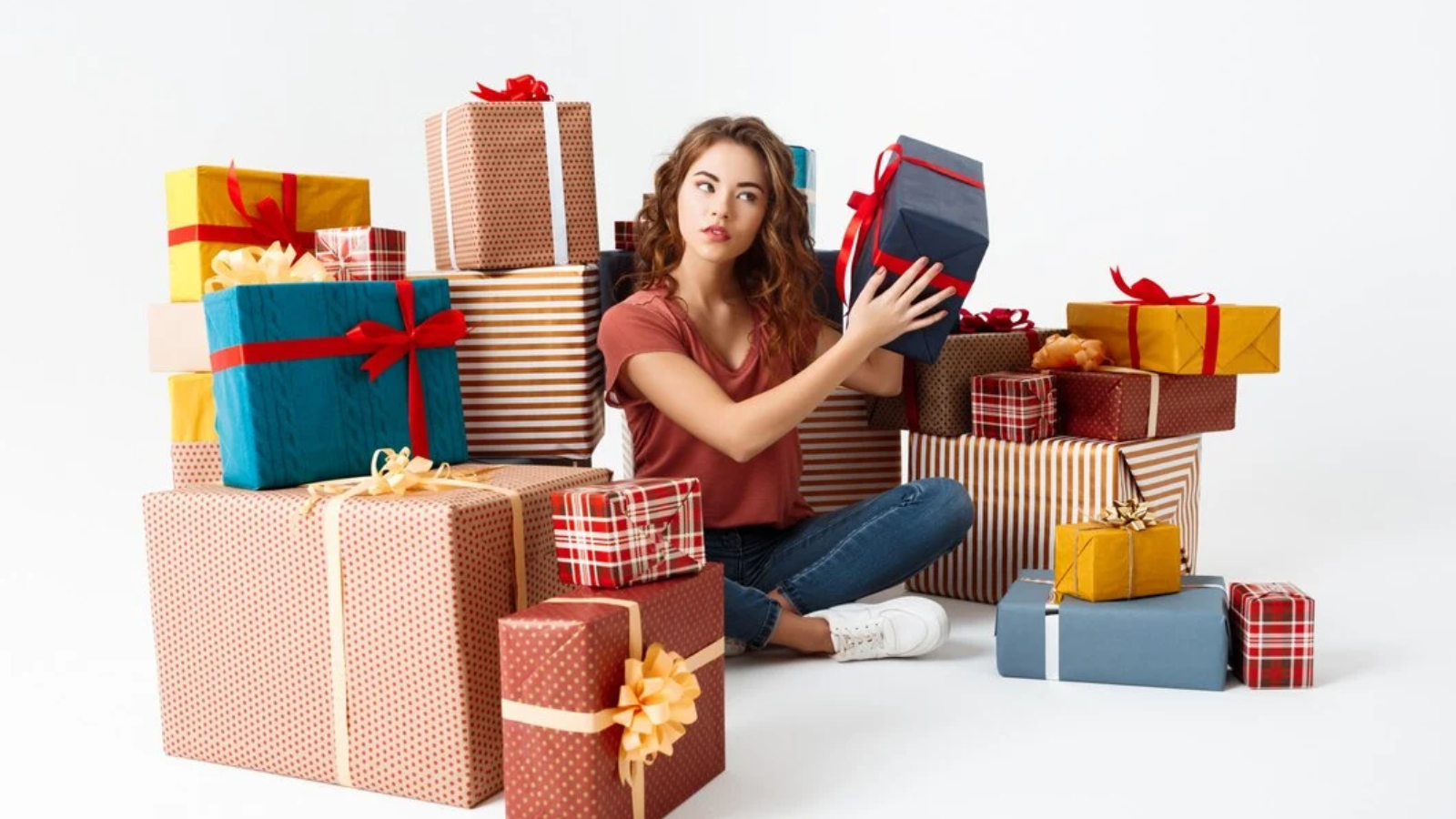 young-curly-woman-sitting-floor-gift-boxes-guessing-what-is-inside_176420-8171